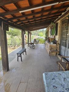 a covered porch with benches and tables on it at Quinta Real Kiwibee in Barrô