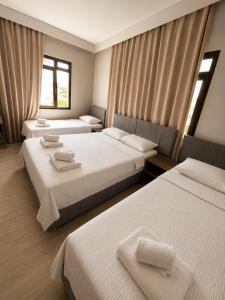 a hotel room with two beds and two windows at Viyana Pansiyon in Çeşme