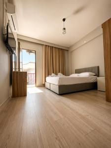 a bedroom with two beds and a large window at Viyana Pansiyon in Çeşme
