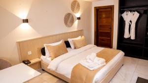 ein Schlafzimmer mit einem Bett, auf dem Handtücher liegen in der Unterkunft Kadiss Hotel in Dakar