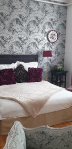 a bedroom with a large bed with purple pillows at Des fleurs au balcon in Quintin