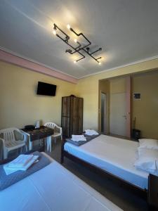 a bedroom with two beds and a desk and a television at Eleni Studio in Paralia Katerinis