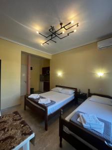 a bedroom with two beds and a chandelier at Eleni Studio in Paralia Katerinis