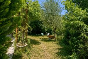 a garden with trees and a bench in the distance at Villa Tromelin in Bouc-Bel-Air