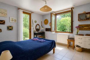 a bedroom with a blue bed and a window at Villa Tromelin in Bouc-Bel-Air