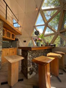 a kitchen with wooden tables and a large window at Domos Blackdomes in Las Trancas