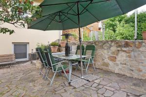 a table with chairs and an umbrella on a patio at Ferienwohnung sehr ruhig in Pößneck