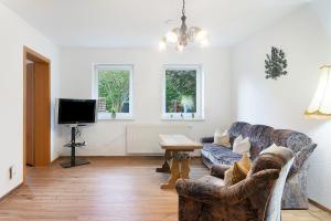 a living room with a couch and a tv at Ferienwohnung sehr ruhig in Pößneck
