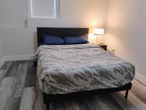 a bedroom with a large bed with a wooden floor at Apartment in Fredericton in Fredericton