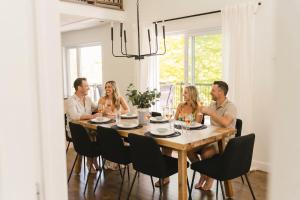 a group of people sitting around a dining room table at Java with Private Spa & Games, Lake & Golf in Saint-Raymond