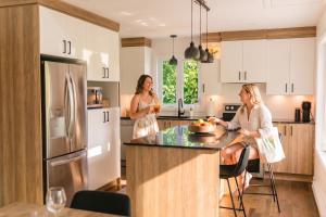 two women are standing in a kitchen at Java with Private Spa & Games, Lake & Golf in Saint-Raymond
