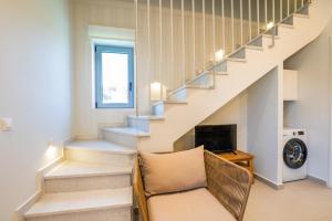 a living room with a couch and stairs at Onyro Villas in Karpathos