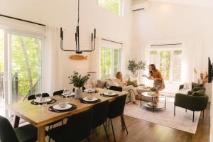 two women sitting in a living room with a table at Java with Private Spa & Games, Lake & Golf in Saint-Raymond