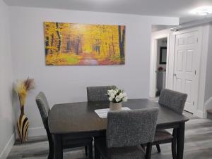 a dining room table with chairs and a painting on the wall at Apartment in Fredericton in Fredericton