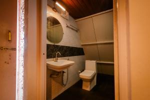 a bathroom with a toilet and a sink at The Breeze Cottage in Kalasa
