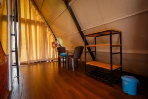 a room with a bunk bed and a table and chairs at The Breeze Cottage in Kalasa