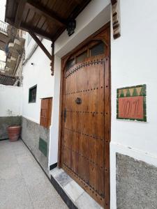 a wooden door on the side of a building at Riad los simbolos in Tétouan +32 photos