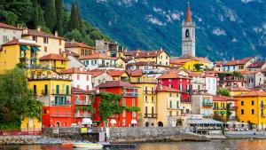 a group of colorful buildings on the side of the water at Frenk house over Varenna in Perledo