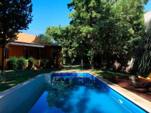 a swimming pool in the yard of a house at Cabañas Estancia Balumba in Capilla del Monte