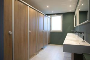 a bathroom with a row of stalls and a sink at Walters Weidelbach in Haiger +22 photos