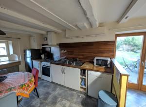 a kitchen with a sink and a stove top oven at Gite Les Sources in Champagney
