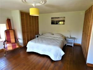 a bedroom with a bed and a chair at Gite Les Sources in Champagney