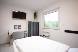 a bedroom with a bed and a desk and a window at Walters Weidelbach in Haiger