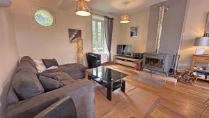 a living room with a couch and a fireplace at Le moulin in Saint-Yrieix-la-Perche