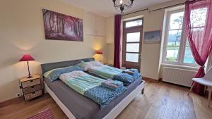a bedroom with a bed and two windows at Le moulin in Saint-Yrieix-la-Perche +43 photos