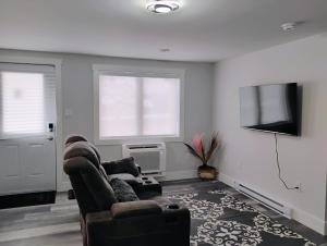 a living room with a couch and a flat screen tv at Apartment in Fredericton in Fredericton