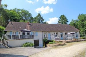 a house with a porch and a driveway at Le moulin in Saint-Yrieix-la-Perche