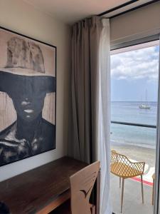 a room with a large window with a view of the ocean at Hotel Ti' Pelican in Saint-Pierre