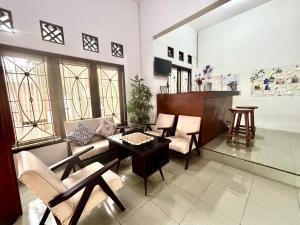 a living room with a couch and a table and chairs at Zzz Ijen Hostel in Banyuwangi