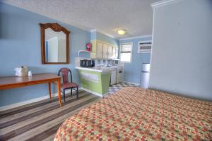 a room with a bed and a desk and a kitchen at El Dorado in Myrtle Beach