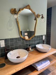 a bathroom with two sinks and a mirror on a counter at La Grange Guesthouse in Beausemblant +17 photos