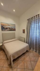 a bedroom with a bed and a large window at Seaview Home Bacoli in Bacoli