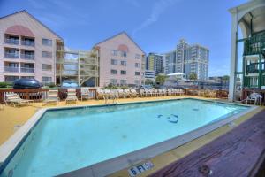 a large swimming pool with chairs and tables and buildings at El Dorado in Myrtle Beach