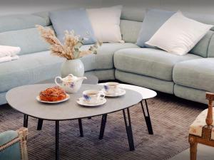 a living room with a coffee table with two cups of coffee at Villa Le Cep - OVO Network in Menthon-Saint-Bernard +21 photos