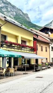 a building with tables and chairs on a street at Albergo Pontafel in Pontebba
