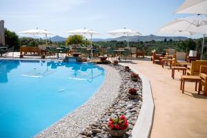 a swimming pool with chairs and tables and umbrellas at Limora' Tenuta Millaci in Mazzarino
