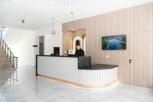 a man sitting at a counter in a lobby at Dorana Toro Hotel in Kyrenia