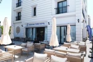 a restaurant with tables and umbrellas in front of a building at Dorana Toro Hotel in Kyrenia