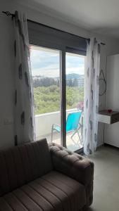 a living room with a couch and a large window at Apartments Bojku in Ulcinj