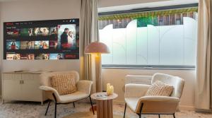 a living room with two chairs and a window at Suite romantique Ibiza, Jacuzzi, Spa in Strasbourg