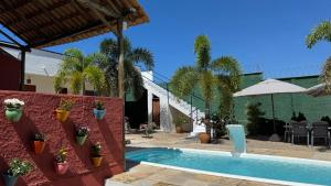 a swimming pool with plants on a red wall at Lounge PDD in Aquiraz