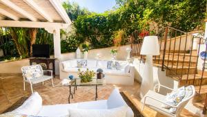 a patio with a couch and chairs and a table at The Queens House in Agrigento