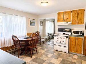 a kitchen with a table and a white stove top oven at Gus & Nellie's Place in Twillingate