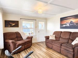 a living room with two brown leather couches at Gus & Nellie's Place in Twillingate