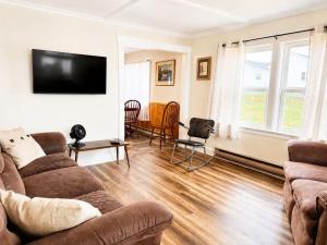 a living room with a couch and a flat screen tv at Gus & Nellie's Place in Twillingate