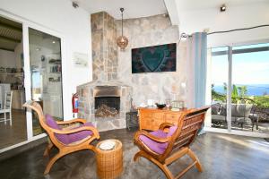 a living room with two chairs and a fireplace at Villa Lorizon in Rodrigues Island